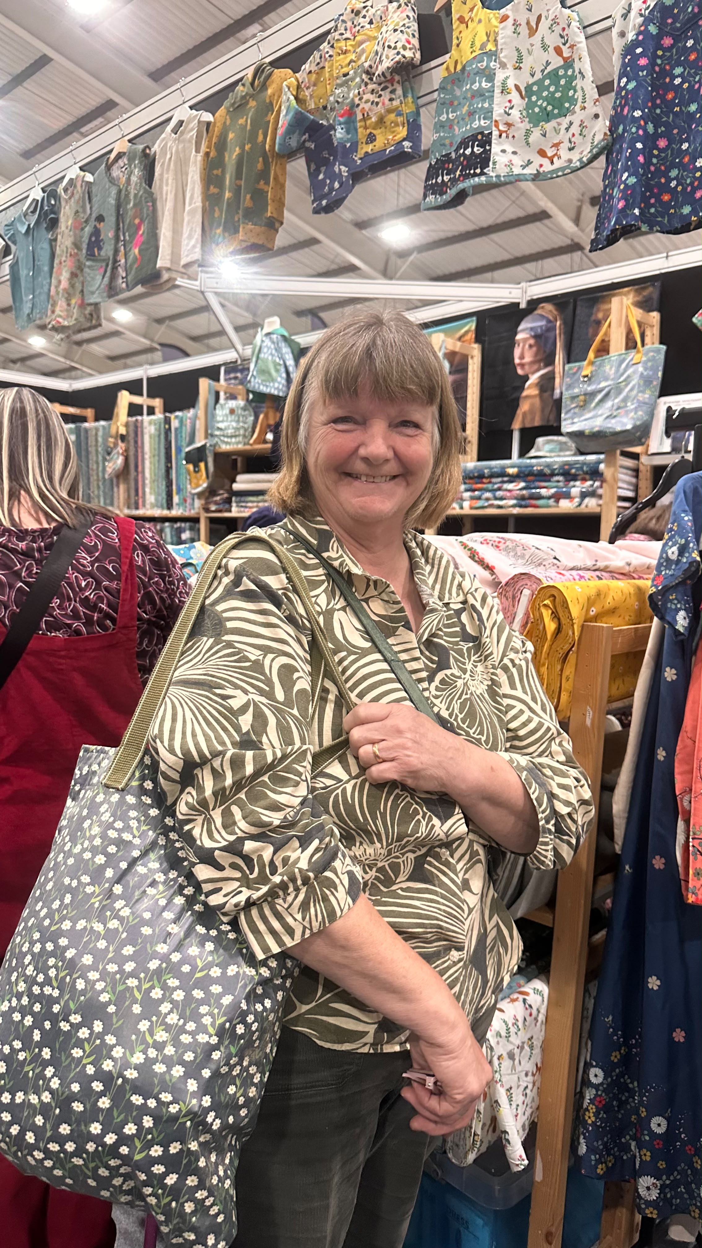 Customer at Exeter Show holding home made Mara tote bag, made from eco-laminated What a Pretty Daisy, dark grey