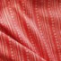 Twill cotton fabric in red with a white geometric print of arrows, dashes, and chevron stripes.