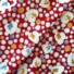 Cotton Dot & Leaf Red. White, orange and light blue dots and leaves on a red background