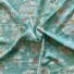 Viscose fly away pistachio. Pale green fabric with mainly white flowers with bits of pink, red and orange