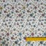 White double gauze cotton fabric with multicoloured small flowers. Ruler on fabric to show flower sizes, approximately 1cm.