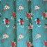 Garden Rose cotton fabric in pastel blue, featuring a pattern of red, pink, and cream roses with white and navy florals, green foliage, and coral berry sprigs on a pastel blue background