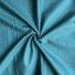 Little Rose cotton fabric in ocean blue, featuring small clustered sprigs of red and cream rosebuds with green leaves scattered on a dark turquoise background, with a fine dotted pattern.