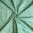 Bee World (sea foam) cotton fabric featuring a scattered pattern of illustrated bumblebees in black, yellow, and white on a green background.