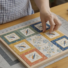 Quilter arranging fabric squares cut using the PNQ Square Stamp Set to create a patchwork design